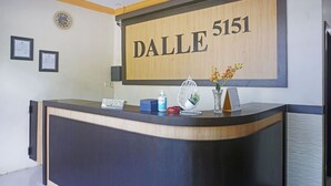 A reception desk with a sign reading "DALLE 5151" and a framed certificate on the wall.