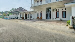 Ein zweistöckiges Gebäude mit Balkon und mehreren Fenstern.