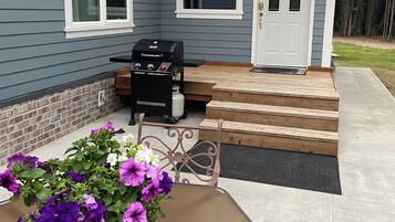 Enjoy outdoor cooking and relaxation on the porch with a barbecue grill and potted plant.