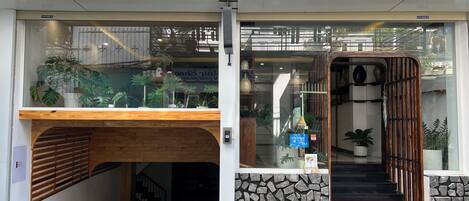 Una entrada moderna a un edificio con un mostrador de madera, una pared de piedra y una escalera que da al interior.