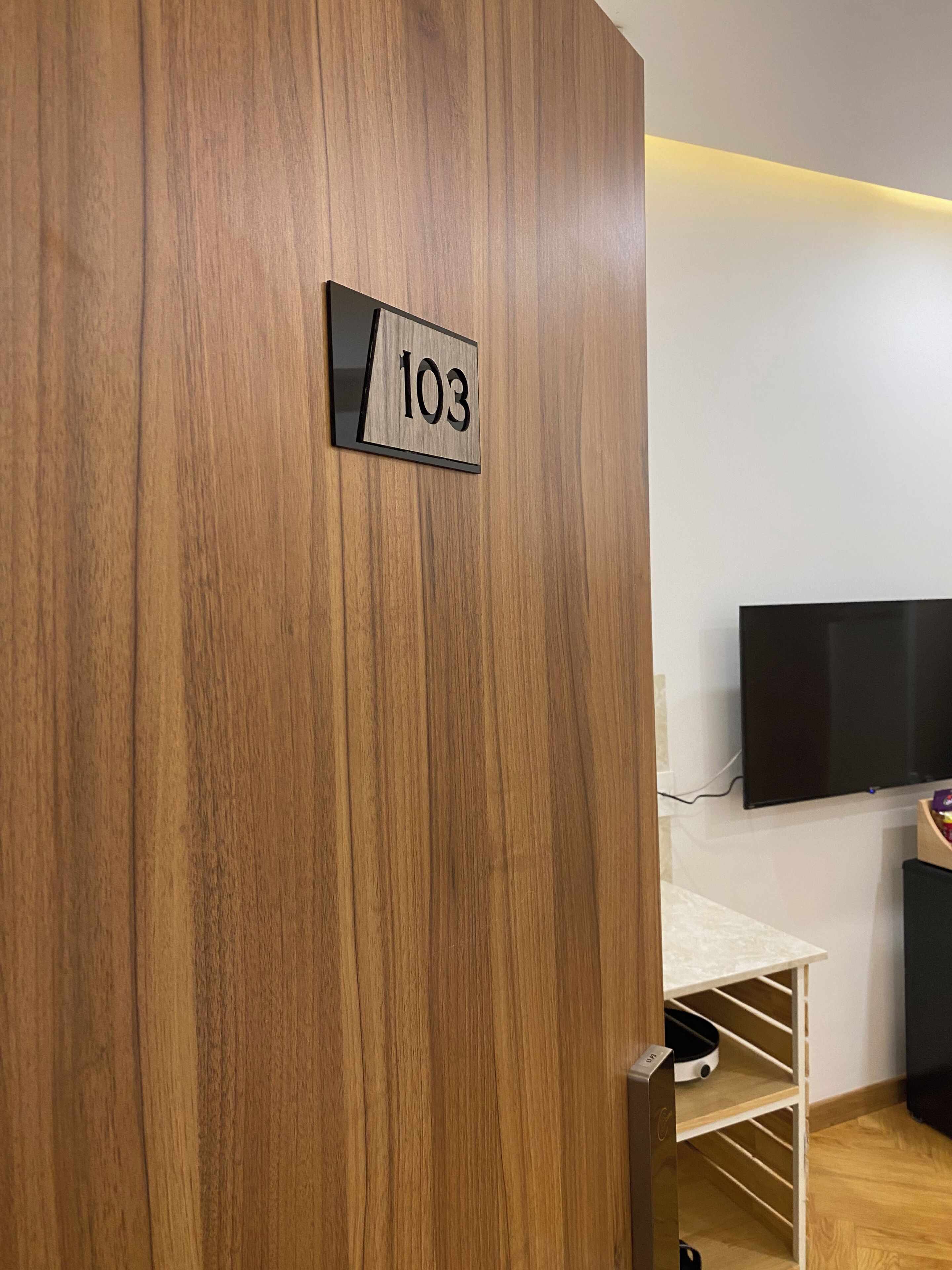 A wooden door with a number plate reading "103".
