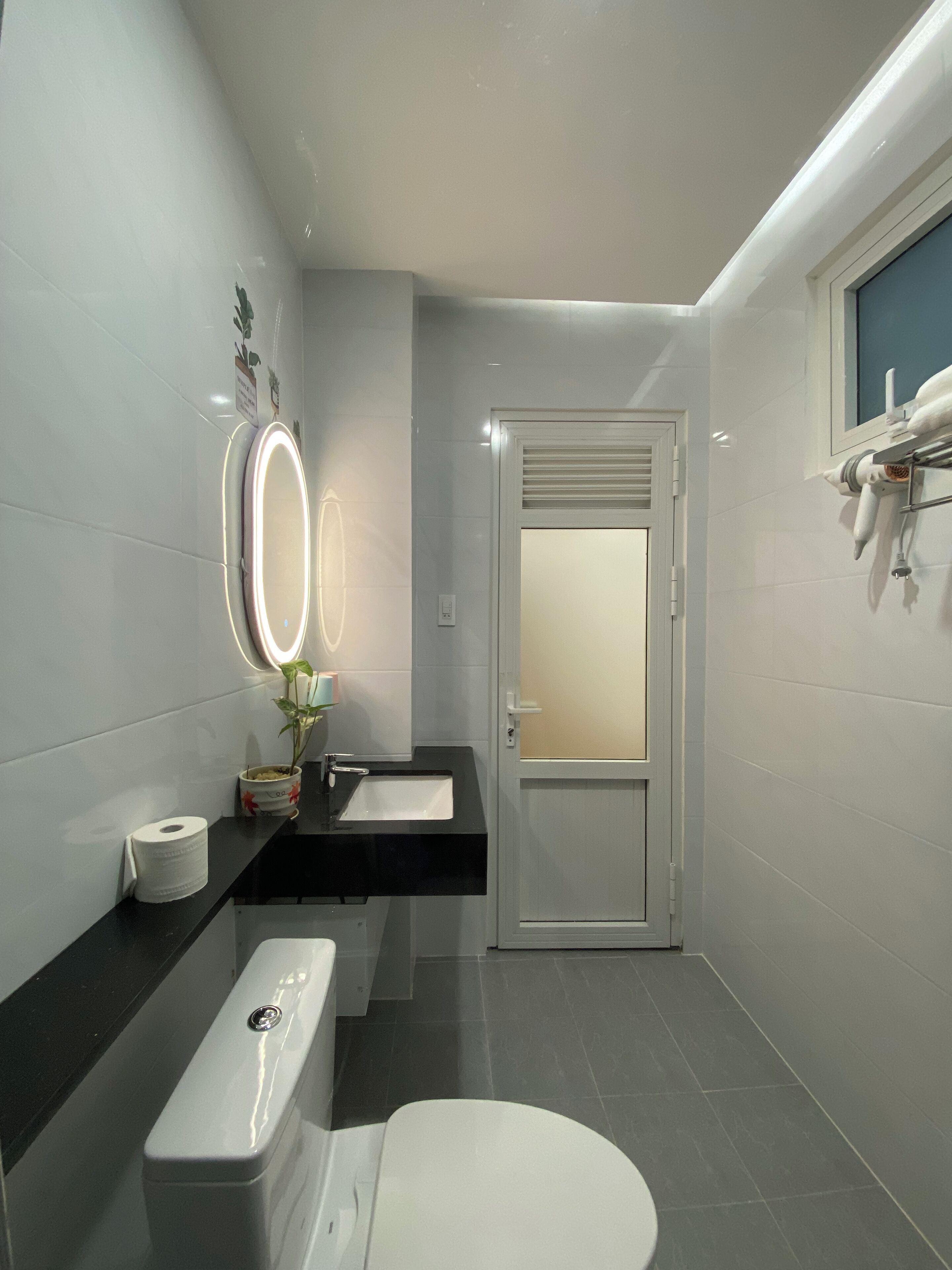 A modern bathroom with a toilet, sink, and mirror.