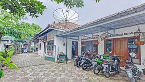 Un patio con pavimento hexagonal, una antena parabólica y varias motocicletas estacionadas.
