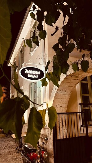 A building with a sign that reads 'Amour Köylikçi' and a bicycle parked outside. - Amour Koyici Otel (Cesme)
