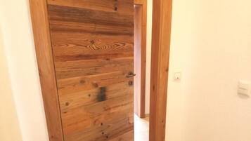 A hallway with a wooden door and a tiled floor.