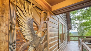 A wooden cabin with a detailed carved eagle on the exterior wall, a wooden deck, and a view of the surrounding landscape. - Blue Ridge Tradition -View, location, dog friendly (Blue Ridge)