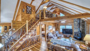 A spacious loft-style living area with a wooden staircase, a fireplace, and a television. - Blue Ridge Tradition -View, location, dog friendly (Blue Ridge)