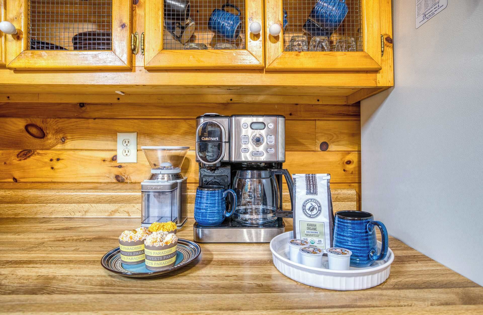 Una kitchenette equipada con cafetera, licuadora y zona de café con tazas y recipientes.
