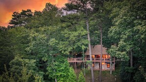 A cabin surrounded by dense forest, with a deck extending over a body of water. - Blue Ridge Tradition -View, location, dog friendly (Blue Ridge)