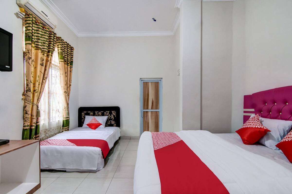Une chambre d’hôtel avec deux lits, une télévision et une porte.