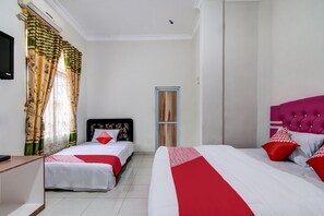 Een hotelkamer met twee bedden, een televisie en een deur.