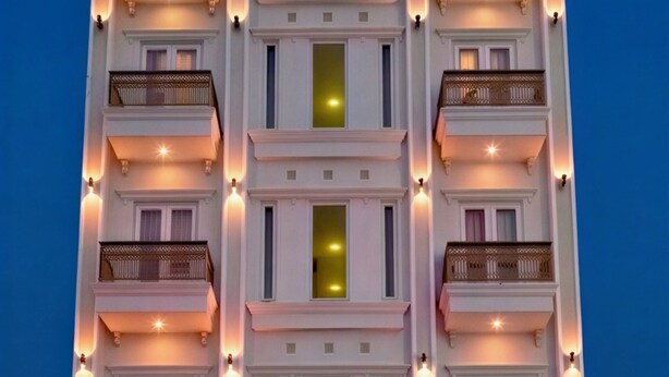 Un hôtel à plusieurs étages, doté de balcons, d’une entrée pour les voitures et d’une enseigne indiquant « SKY STAR HOTEL ».