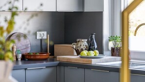 Una cocina moderna con armarios grises, encimera de madera y ventana con vistas.