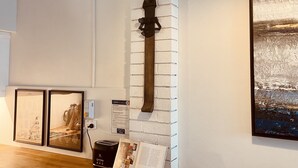 A modern interior with a wooden dining table, a mounted sword, and framed artwork on the walls.