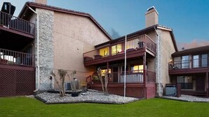 A two-story building with a stone facade, a balcony with a railing, and a small garden area with gravel and plants. - 2BDR/2.5BTH, located less than 2 miles from Canyon Lake. Hot-tub, stunning views, nearby golf course (Canyon Lake)