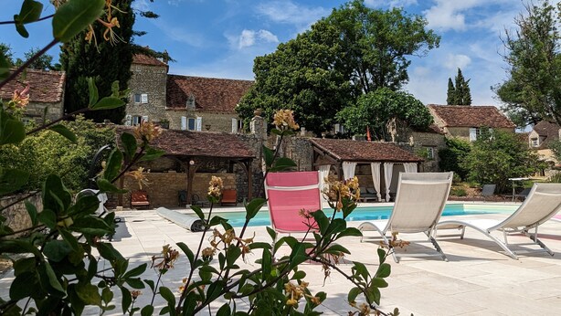 A pool area with lounge chairs, a stone building, and lush greenery. - Romantic french cottage 6 persons with pool, 15 min from Rocamadour/Dordogne (Reilhaguet)