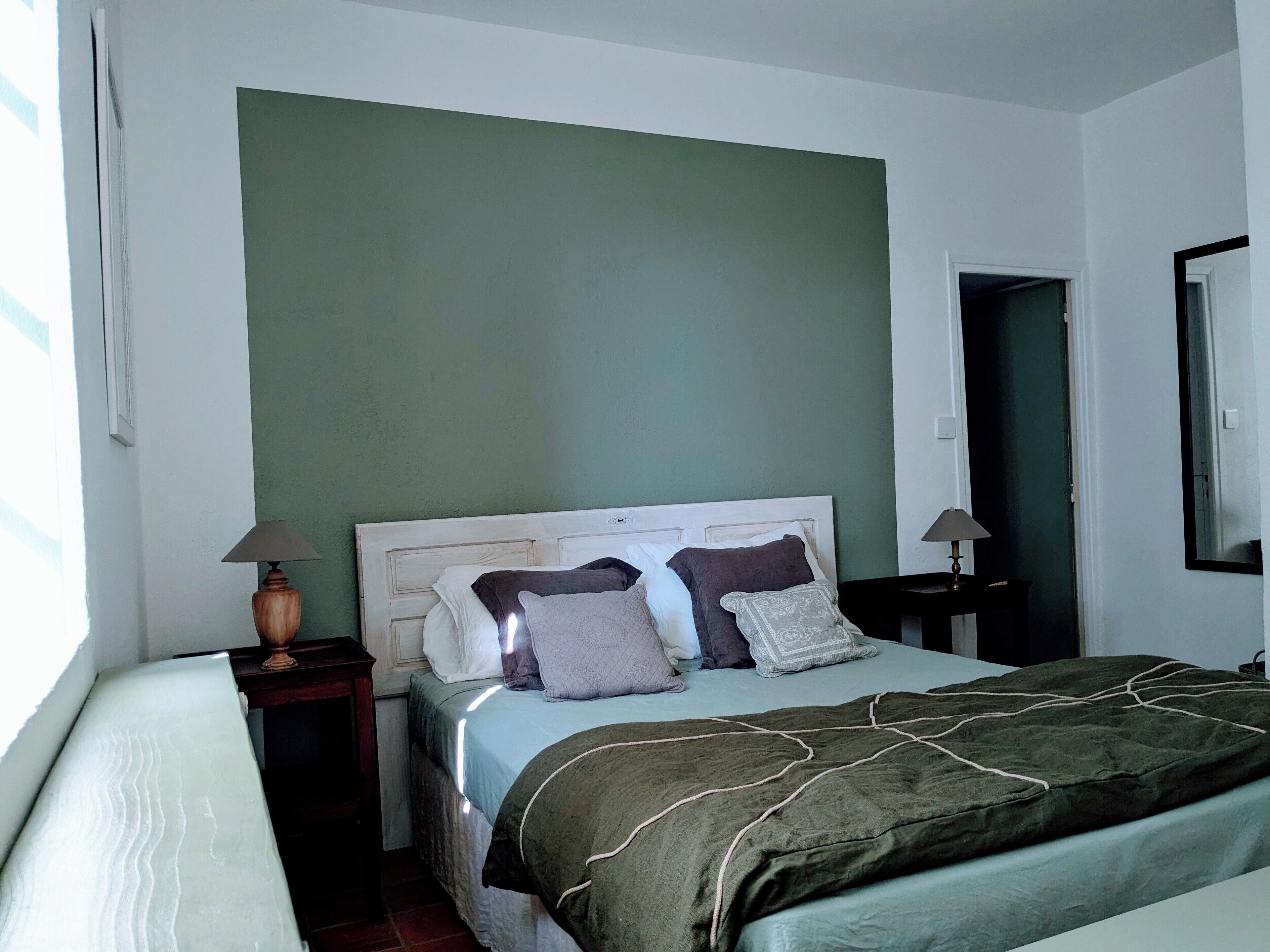 Une chambre à coucher avec un lit, deux tables de chevet et une fenêtre.