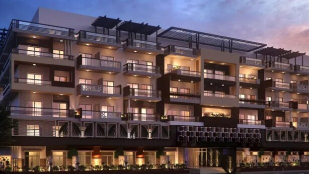 A multi-story hotel with balconies, a covered walkway, and a well-lit facade. - JVC studio Joya Verde with terrace - 360 vacation (Dubai)
