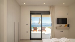 Camera da letto con un letto, una TV e vista su una piscina e montagne.