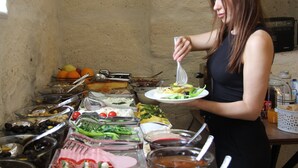 Un buffet con diversi cibi e una persona che si serve.
