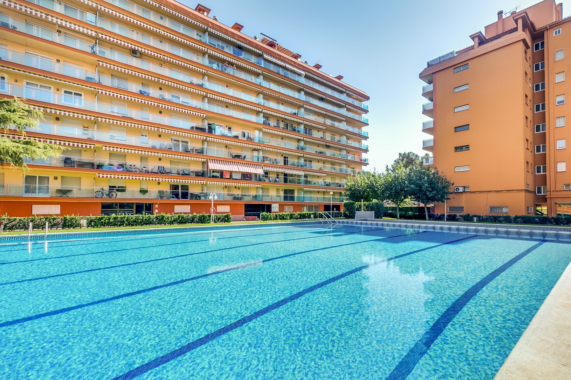 A multi-story hotel with a swimming pool in the foreground.