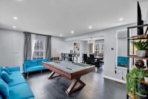 Relax and socialize in this inviting space featuring a central pool table and dining area.