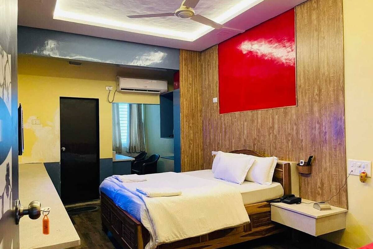 A hotel room with a bed, bedside table, and a ceiling fan.