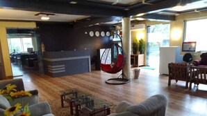 Un área de lounge moderna con un sillón colgante, sofás y una mesa de centro.