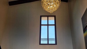 Una entrada imponente con un amplio arco, una araña de cristal y vistas al exterior.