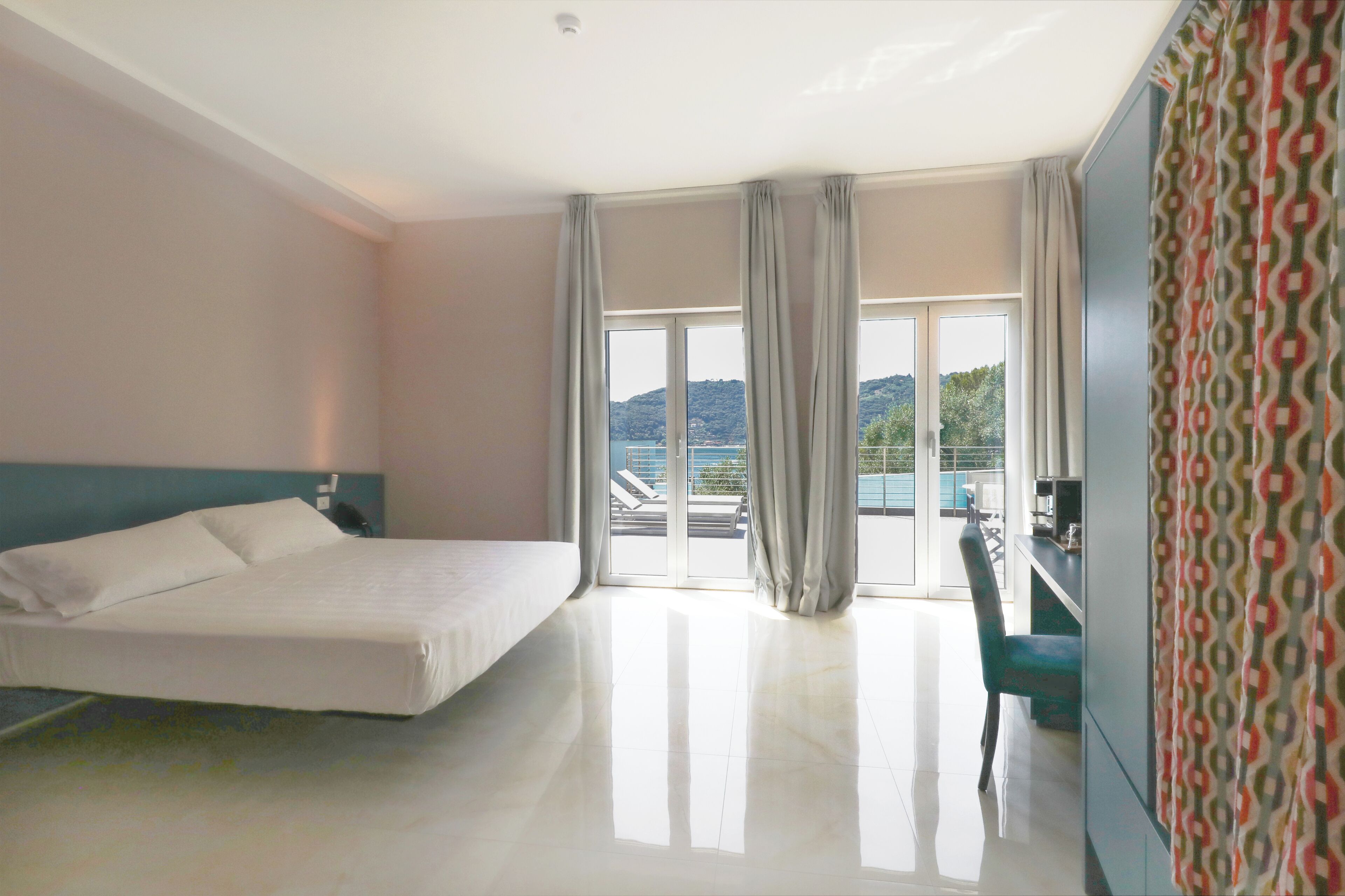Una habitación de hotel con cama, escritorio y vista al exterior.