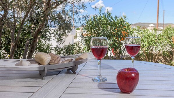 A table with two wine glasses, a bowl of bread, and an apple. - Happy Stay Apartment (Milos)
