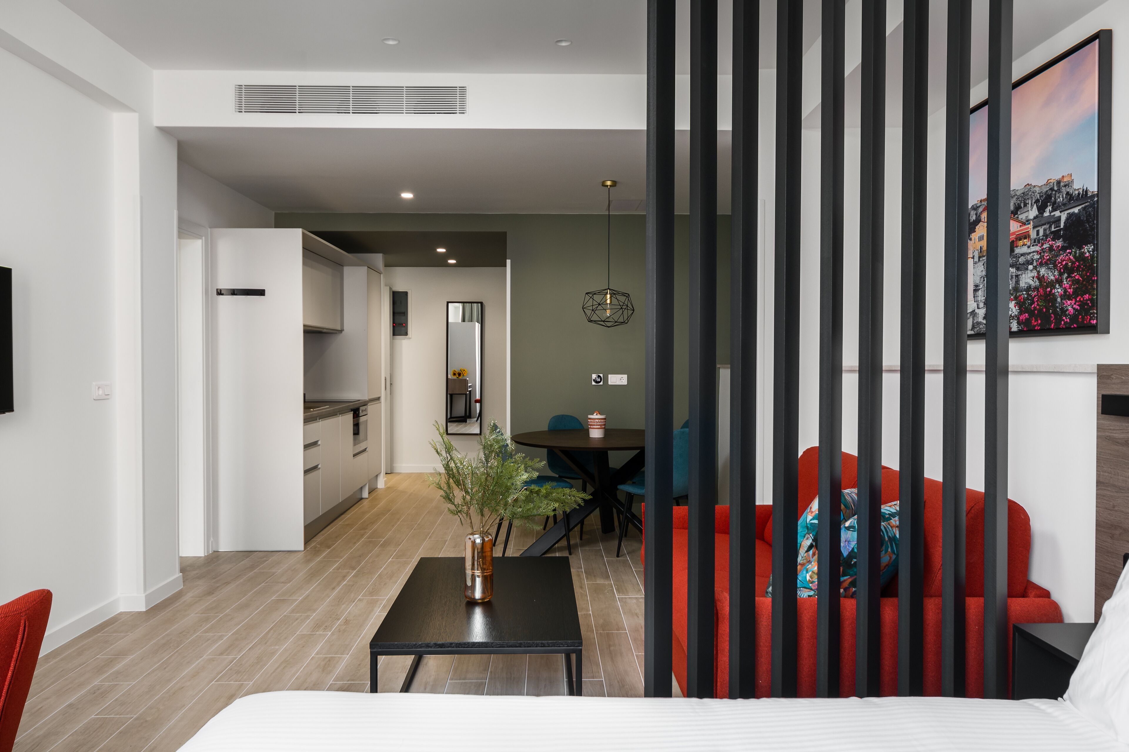 A modern living room with a sofa, a coffee table, and a dining area with chairs.