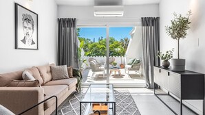 Un salon moderne avec un canapé, une table basse et une vue sur la terrasse extérieure.