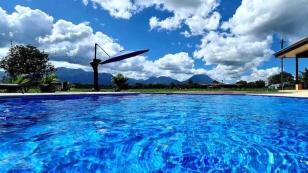 Una piscina con vista despejada a las montañas al fondo.