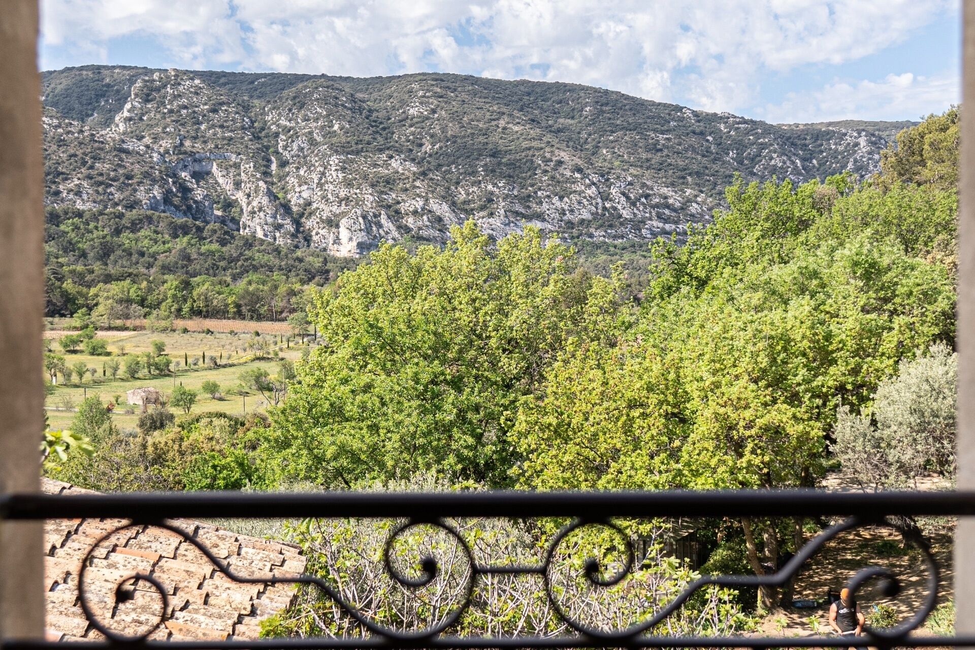 A mountainous landscape with a view of a valley and a building with a metal fence in the foreground.