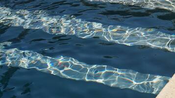 Una piscina cristalina con visibles ondulaciones y reflejos.