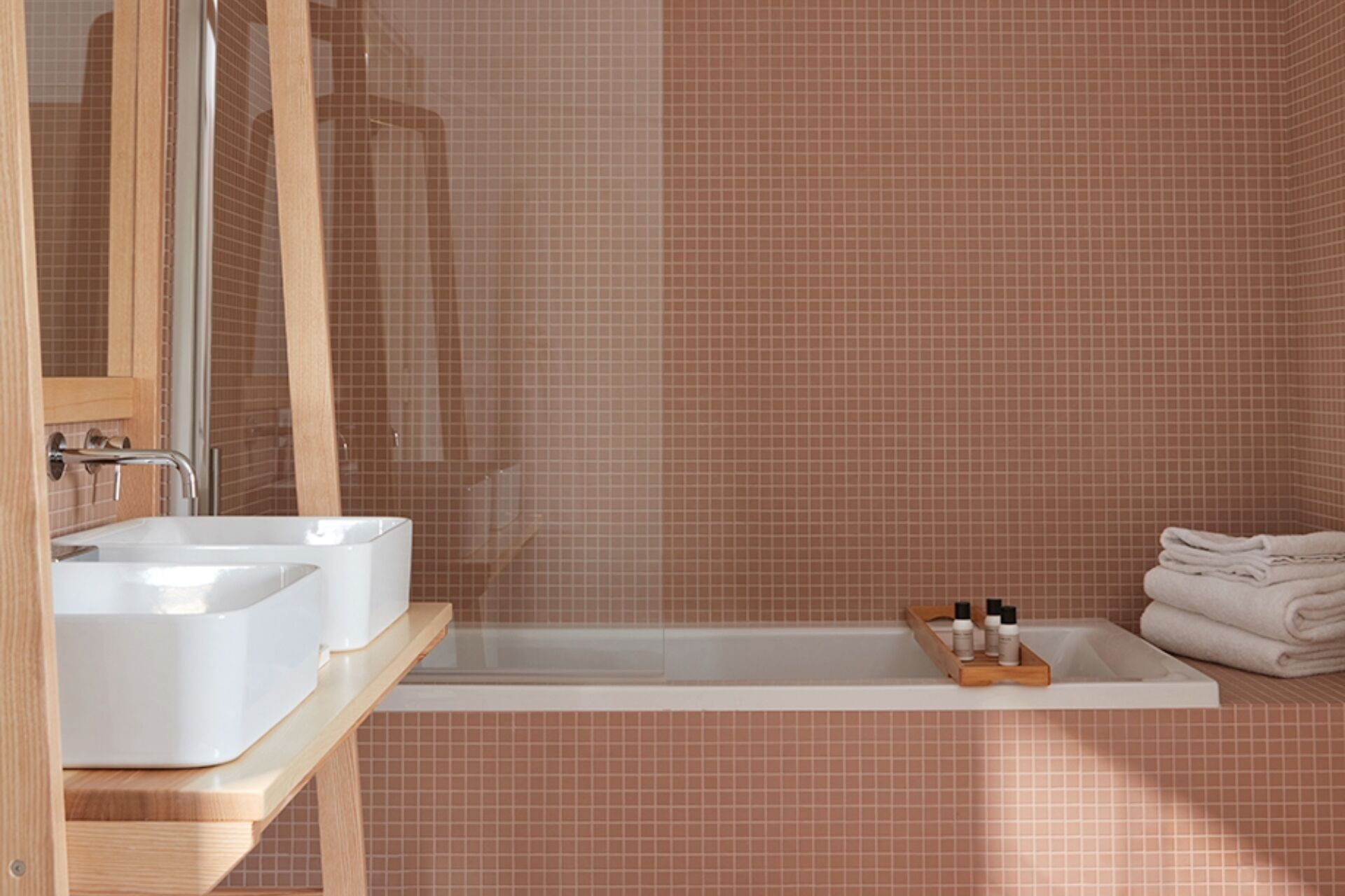 A bathroom with two sinks, a bathtub, and a towel rack.