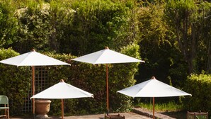 A pool area with lounge chairs and umbrellas.