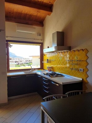 Een koelkast, een kookplaat, een koffiezetapparaat/waterkoker, eettafels