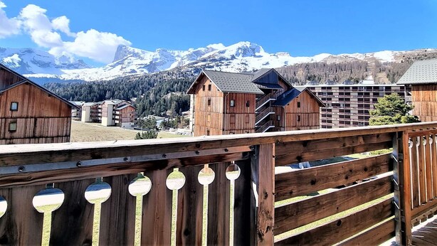 A wooden building with a balcony overlooking a mountainous landscape.
