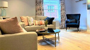 A living room with a sofa, armchair, and coffee table.