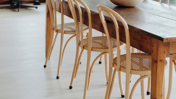 A dining area with a wooden table and chairs, large windows, and a view of the outdoors. - Massinger Views Byron Bay (Byron Bay)