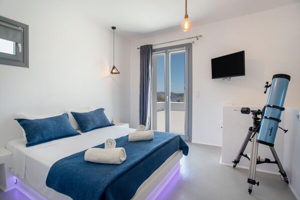 A bedroom with a bed, a telescope, a television, and a sliding glass door.