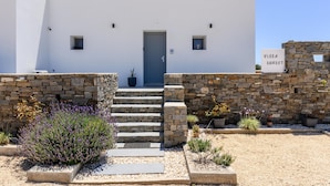 Un bâtiment avec une porte bleue, des marches en pierre et une enseigne indiquant « Villa Sunset ».