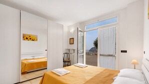 Une chambre Ă coucher avec un lit, une chaise, une fenĂŞtre et une porte.
