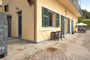 A building with a stone facade, a door, and a window with shutters.