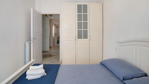 A bedroom with a bed, a wardrobe, and a bathroom visible through an open door. - Apartment 'Mari Fior' with Sea View, Balcony and Wi-Fi (San Bartolomeo)
