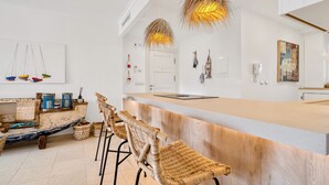 A modern bar area with wicker chairs, a wooden counter, and decorative hanging lights. - Villa Gadea 7-2 Apartment with Sea Views, Wi-Fi, and Air Conditioning (Altea)