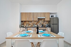 A modern kitchen with wooden cabinets, a tiled backsplash, and a stainless steel refrigerator.