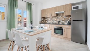 Una cocina moderna con armarios de madera, un refrigerador de acero inoxidable y un salpicadero de azulejos.